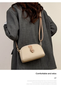 Detail of beige faux leather crossbody bag with pebble texture and gold hardware on model