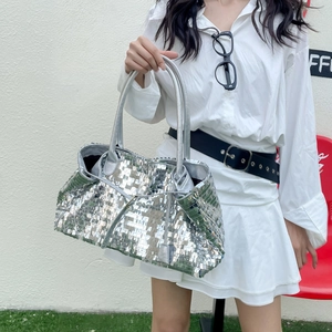 Detailed close-up of sparkling silver sequins on a stylish tote bag with metallic handles