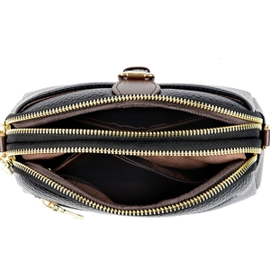 Detailed view of triple-layer zipper structure and inner lining of soft leather crossbody bag
