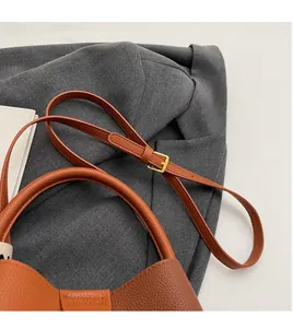 Close-up of litchi texture leather bucket bag with adjustable strap and gold hardware