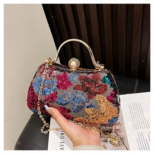 Detail of colorful sequin evening bag with gold handle and pearl clasp accessory