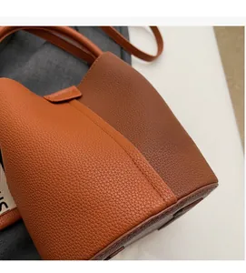 Detailed macro view of litchi texture leather and reinforced stitching on a bucket bag