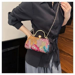 Detail of colorful sequin embroidery and large pearl clasp on elegant evening clutch bag