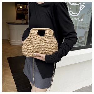 Detailed straw woven texture and metallic gold chain strap on minimalist beige handbag