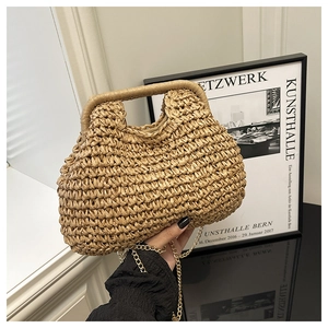 Detail of woven straw bag with leather handle and detachable gold chain strap
