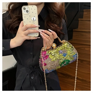 Detail of colorful sequin evening bag with gold handle, pearl clasp and chain strap