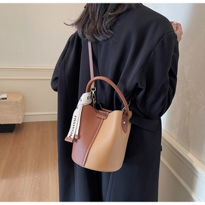 Detailed back view of a color-block bucket bag in brown lychee pattern leather with scarf