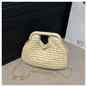 Detail of cream woven straw bag with wide handles and gold chain strap close-up