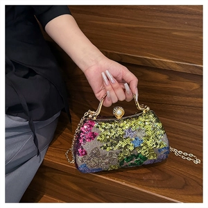 Detail of colorful sequin evening bag with gold handle and pearl clasp decoration