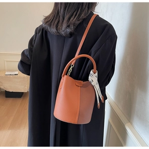 Litchi pattern bucket bag with metal ring handle and decorative silk scarf side detail