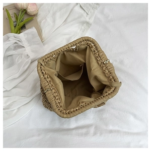 Top view of straw bag interior showing canvas lining and metal frame closure detail