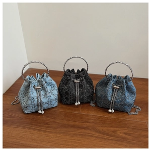 Trois sacs seaux en denim bleu clair, bleu foncé et noir avec texture losange et poignées
