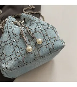 Détails du sac seau en denim avec sequins argentés, perles et cordon de serrage en chaîne