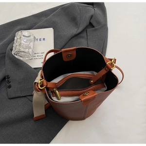 Detailed interior of brown litchi pattern bucket bag with zipped pouch and magnetic closure