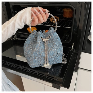Détails du sac seau en denim avec paillettes argentées et breloques de cordon en perles