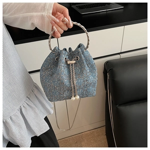 Détail du sac seau en denim avec paillettes argentées et cordon de serrage en perles