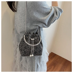 Vue détaillée du sac seau en tweed gris foncé avec perles élégantes et bandoulière chaîne