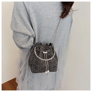 Détails de ce sac seau en tweed avec cordon à perles et poignée métallique chic