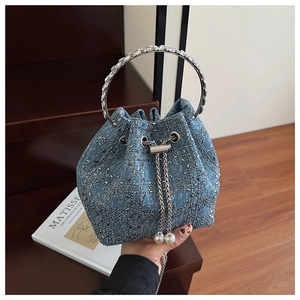 Détail du sac seau en jean avec motifs en strass et grandes perles sur le cordon