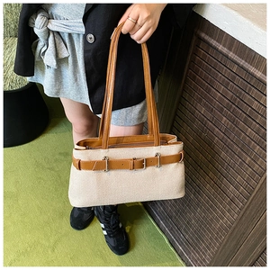 Détail du sac cabas tissé avec sangle en cuir marron et deux poignées de style français