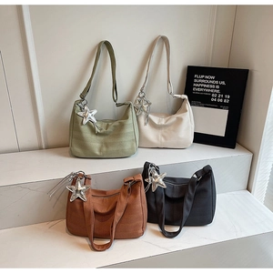 Detail of four colorful crescent tote bags with star charms on white display steps