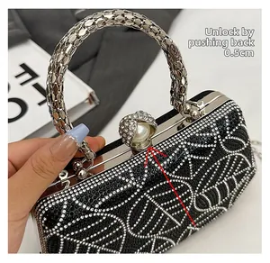 Detail of the elegant black rhinestone clutch bag with pearl clasp and silver metal handle