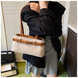 Détail d'un sac cabas en toile de qualité avec anses en cuir marron et boucle métallique