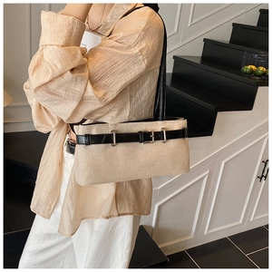 Détail du sac fourre-tout beige clair texturé avec lanières en cuir noir et boucle en métal