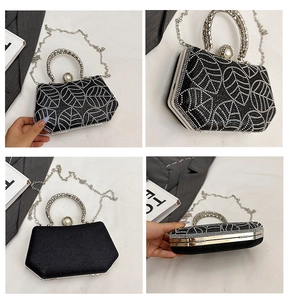 Detail of black hexagonal evening bag with leaf pattern rhinestones and ring handle