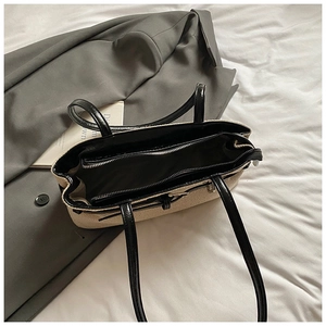 Vue de dessus du grand sac cabas en paille avec bordure en cuir noir et poche zippée