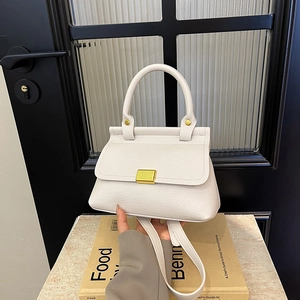 Borsa a mano bianca in pelle martellata con fibbia dorata e manico in un set di lifestyle