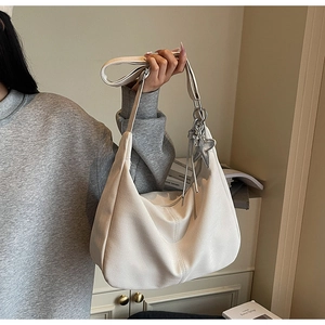Close-up of beige hobo bag texture with star pendant and spacious interior detail