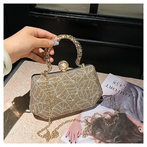 Macro detail of luxury gold rhinestone evening bag with elegant pearl clasp and round handle