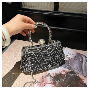Detail of black rhinestone evening bag with pearl clasp and silver metal ring handle