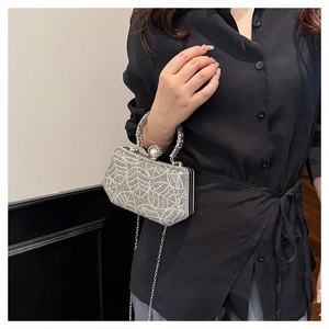 Macro shot of silver rhinestone evening bag with leaf patterns and large pearl clasp