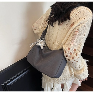 Close-up of dark grey woven tote bag featuring diagonal twill texture and star pendant
