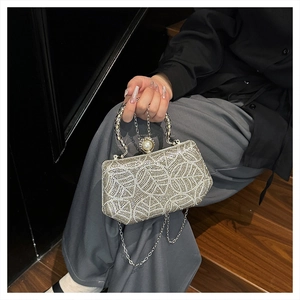 Detail of silver rhinestone evening clutch bag with pearl decor and chain strap