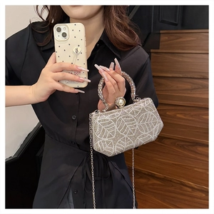 Detail of silver rhinestone evening bag with leaf patterns and elegant pearl clasp closure