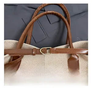 Detail shot of woven tote bag featuring premium leather strap and gold D-ring hardware