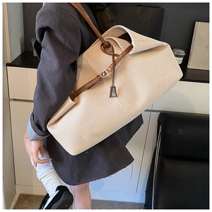 Close-up of beige woven canvas tote bag with brown leather straps for commuting