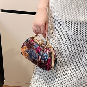 Elegant evening clutch with colorful sequins, pearl clasp, and gold chain strap held by model