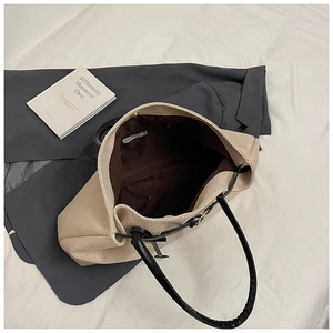 Close-up of the beige woven tote bag interior showing the brown lining and large capacity