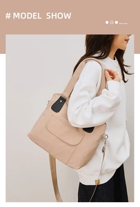 Détail du sac cabas en toile avec touches de cuir noir et bandoulière ajustable