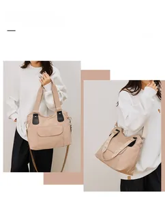 Détail du grand sac cabas en toile abricot avec bandoulière réglable et design épuré