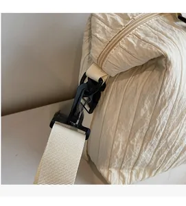 Détail du crochet rotatif noir et du tissu plissé sur le sac bandoulière beige