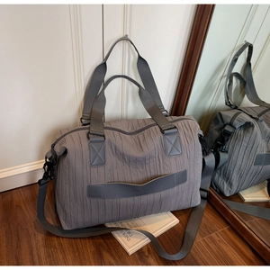 Détail du sac à épaule plissé gris avec poignées larges et bandoulière réglable