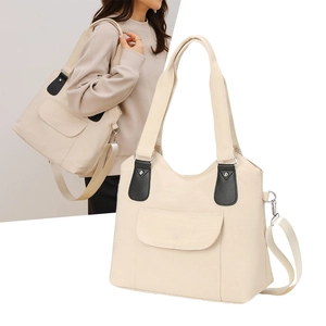 Détail du sac cabas beige montrant la ferrure métallique et la bandoulière réglable