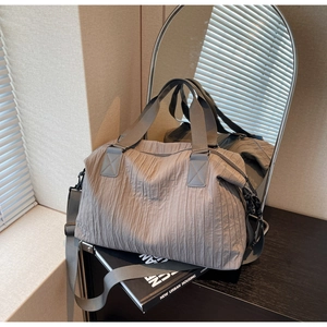 Détail de la texture plissée grise sur un sac fourre-tout moderne en nylon léger