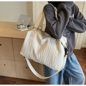 Détail du sac cabas plissé blanc montrant la texture du tissu et la large bandoulière