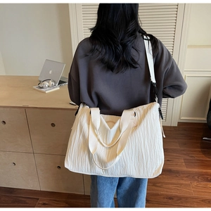 Détail du sac fourre-tout plissé blanc cassé avec une large bandoulière pour le quotidien